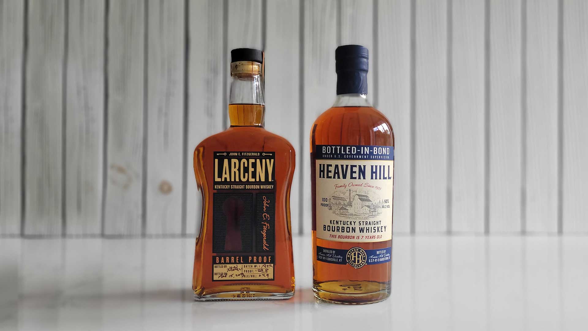 Bottles of Heaven Hill Bottled-in-Bond and Larceny Barrel Proof Whiskey on a counter.