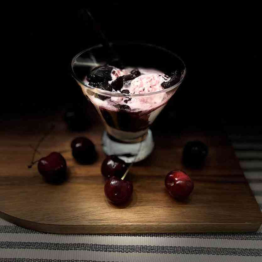 Smoked bourbon cherry sauce poured over ice cream.