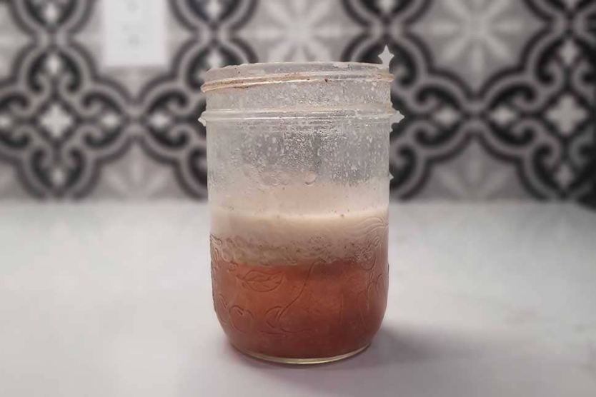 Jar of bourbon with frozen bacon fat on top.